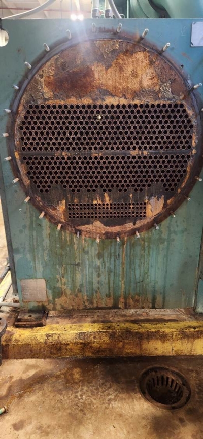 Corroded tube sheet with heavy rust and surface degradation before repair.