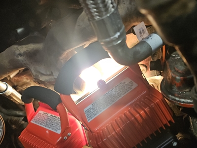 Heat lamps applied to engine block during repair process.