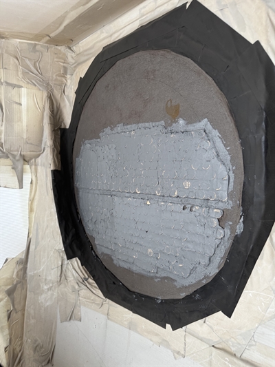 Tube sheet undergoing repair with Belzona 1111 applied over blasted surface, masking in place.