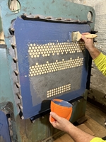 Technician applying first coat of Belzona to tube sheet surface.