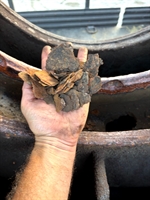 Hand holding rust flakes from inside corroded fire pump casing.