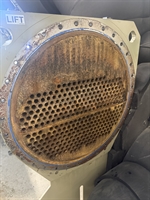 Corroded heat exchanger tube sheet with visible rust and metal loss prior to surface preparation.