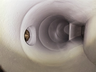 A large tube inside a Francis turbine with a pale coating