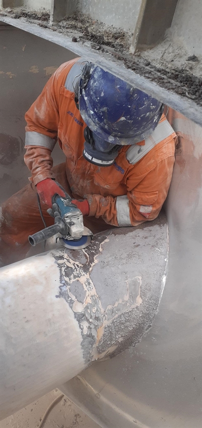 A man using a power tool is preparing the surface area
