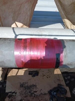 Pipe in mid repair with tape wrapped around the repair to seal it