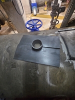two steel plates next to the cleaned surface of the pipe, ready to be fitted around the nozzle